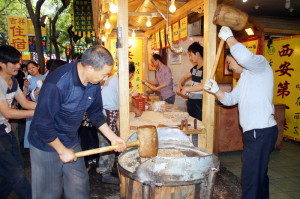 Hier wordt met hamers een brei van pinda's, gecaramelliseerde suiker en sesamzaad tot een platte lap geslagen die tot een soort bladerdeeg gevouwen wordt.