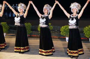 600 mensen werken mee aan de show, veelal in de diverse tradiotionele kostuums van etnische minderheden in China. Linksachter de verlichte kostuums.