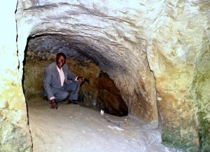 De man brengt ons naar de ingang van de grot